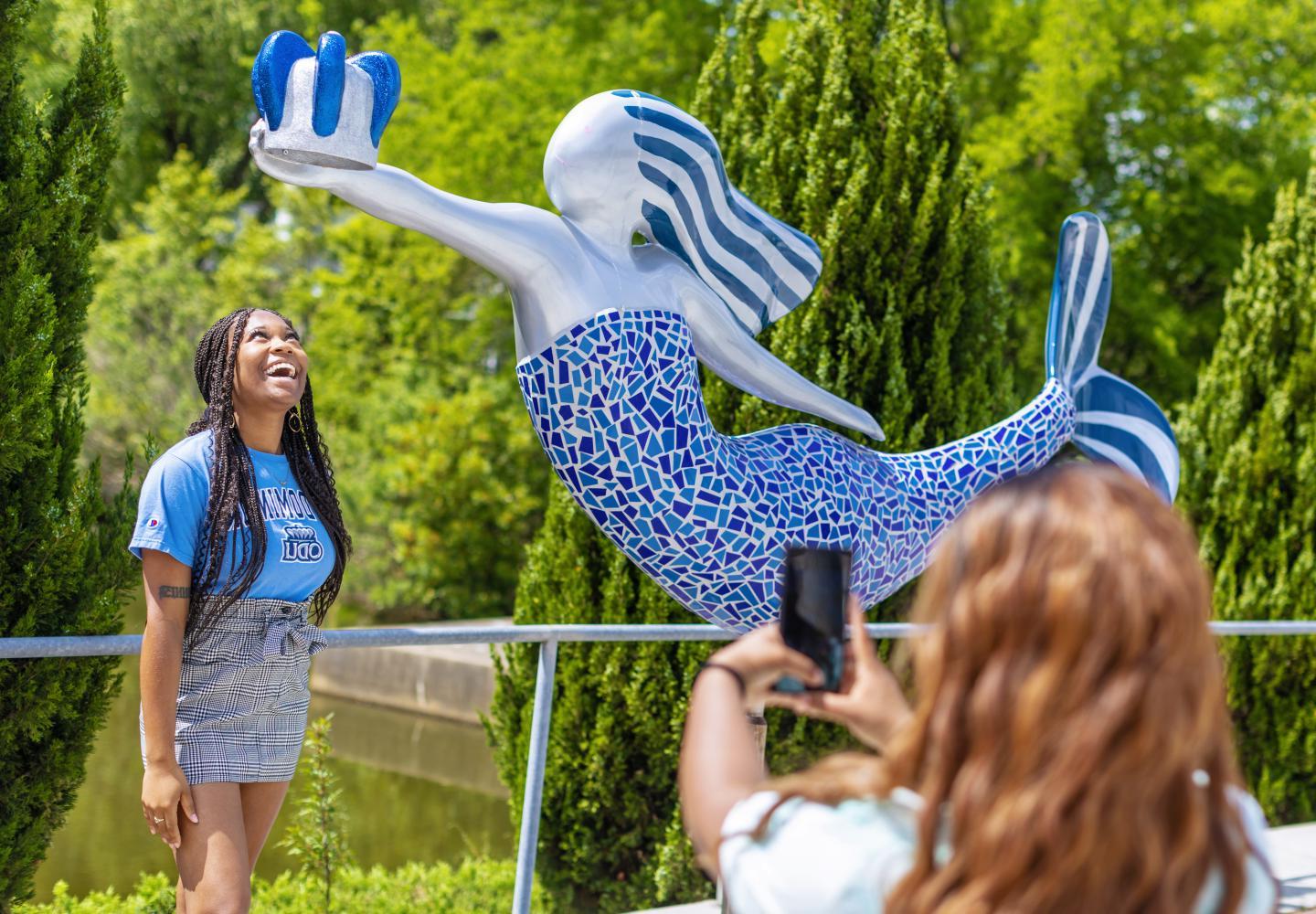 一名ODU女学生站在美人鱼雕像下