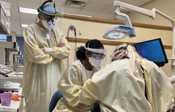 dental hygiene students work on a patient 