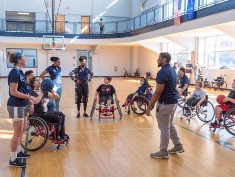 在ODU体育馆，学生们与坐轮椅的孩子们一起工作