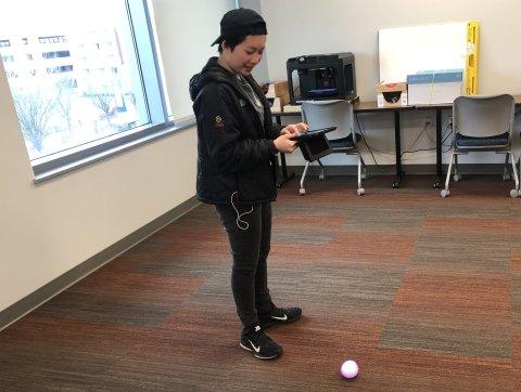 Student uses Sphero robot.