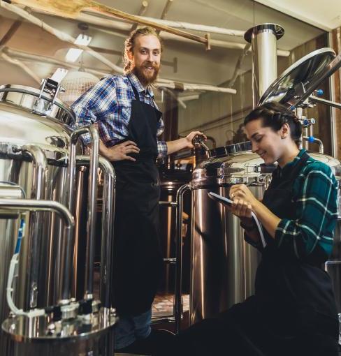 Man and woman brewing beer with giant mashtons